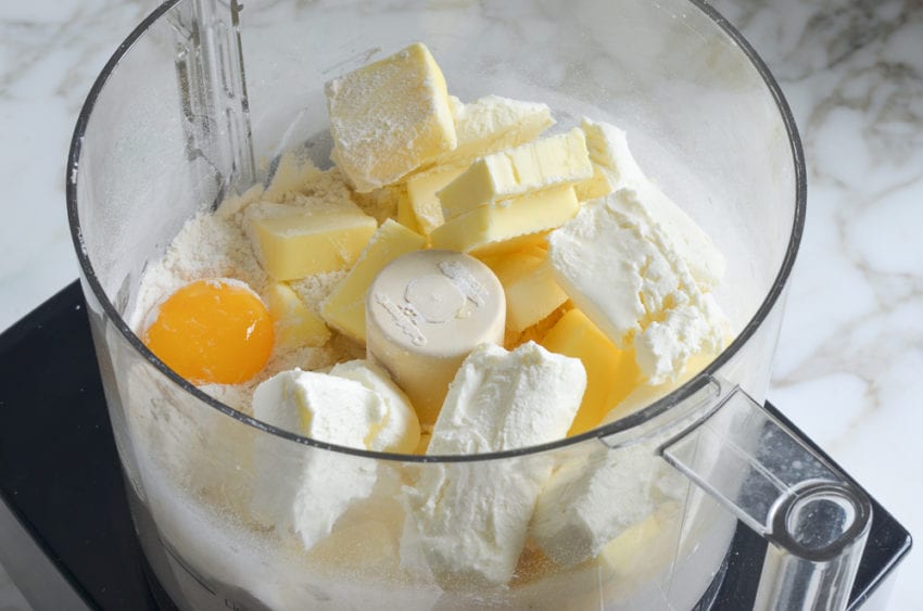 Butter, cream cheese, and egg yolk in a food processor with dry ingredients.
