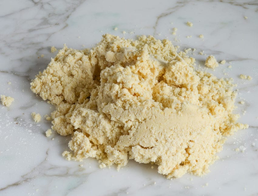 Pile of crumbly dough on a countertop.