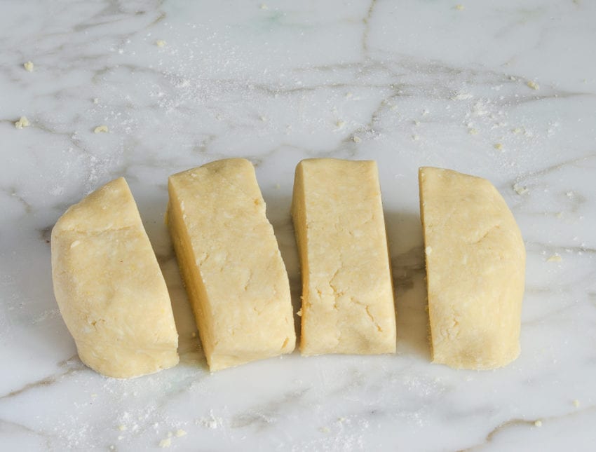 Four pieces of dough on a countertop.