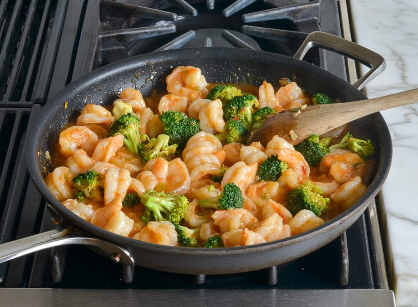 Shrimp and broccoli mixture in a skillet.