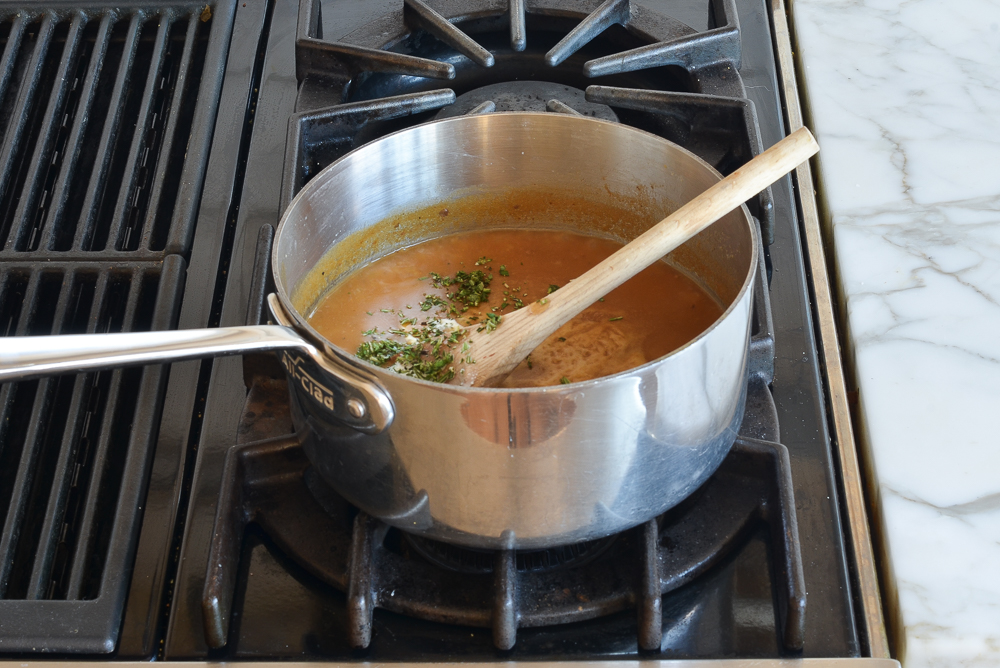 Herbs in a sauce pan of gravy.