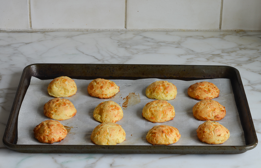Gougeres on a lined baking sheet.