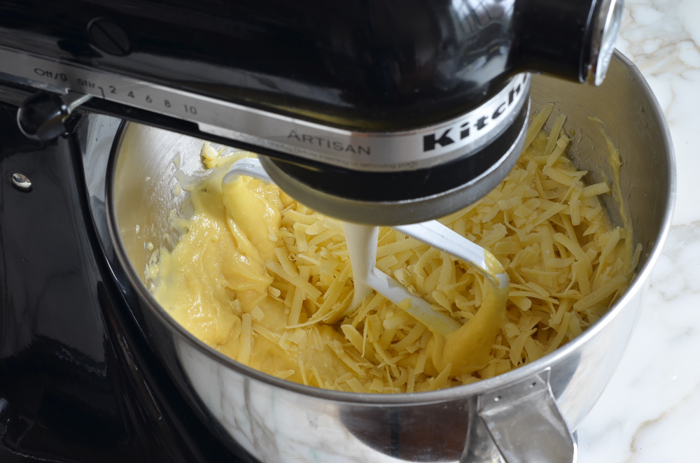 Shredded cheese in a bowl with dough.