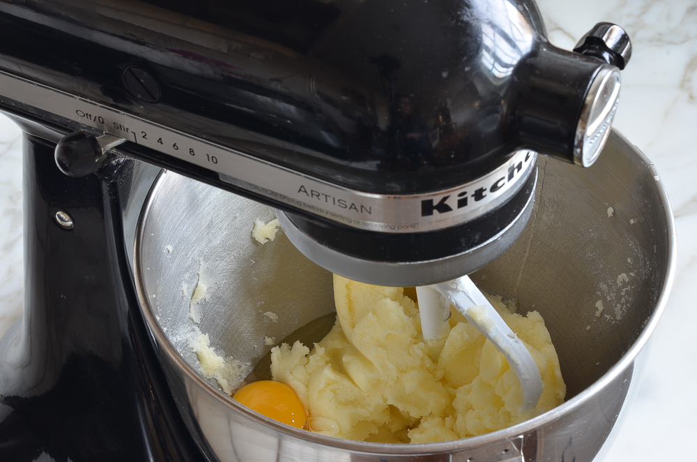 Egg in a stand mixer with a butter and sugar mixture.