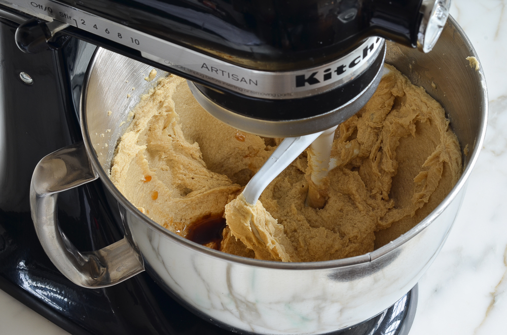 Vanilla in a stand mixer with a butter mixture.