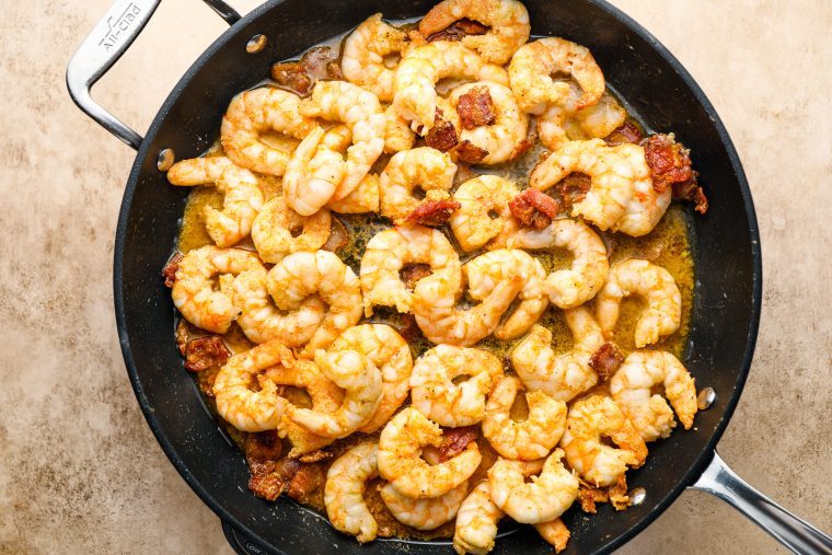 Shrimp and bacon in a skillet.
