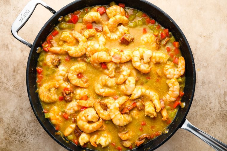 adding shrimp and bacon to sauce