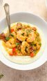 Spoon in a bowl of shrimp and grits.