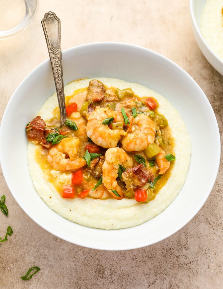 Spoon in a bowl of shrimp and grits.