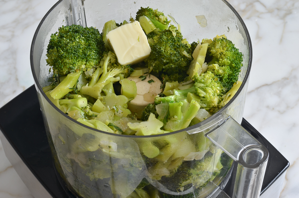 Pat of butter in a food processor with cooked broccoli.