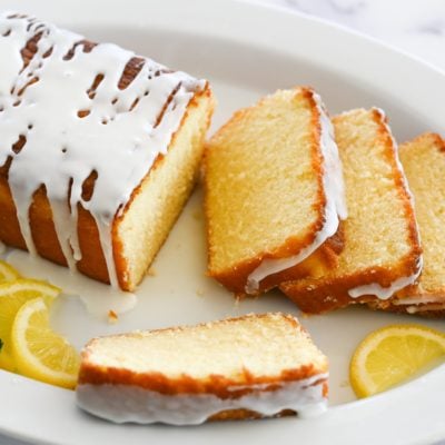 Partially sliced lemon pound cake on a plate.