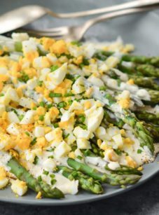Plate of asparagus salad with hard-boiled eggs and creamy dijon dressing.