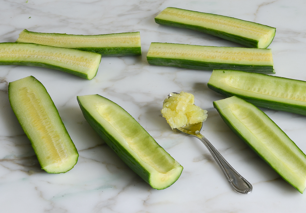 Spoon removing the seeds from cucumbers.
