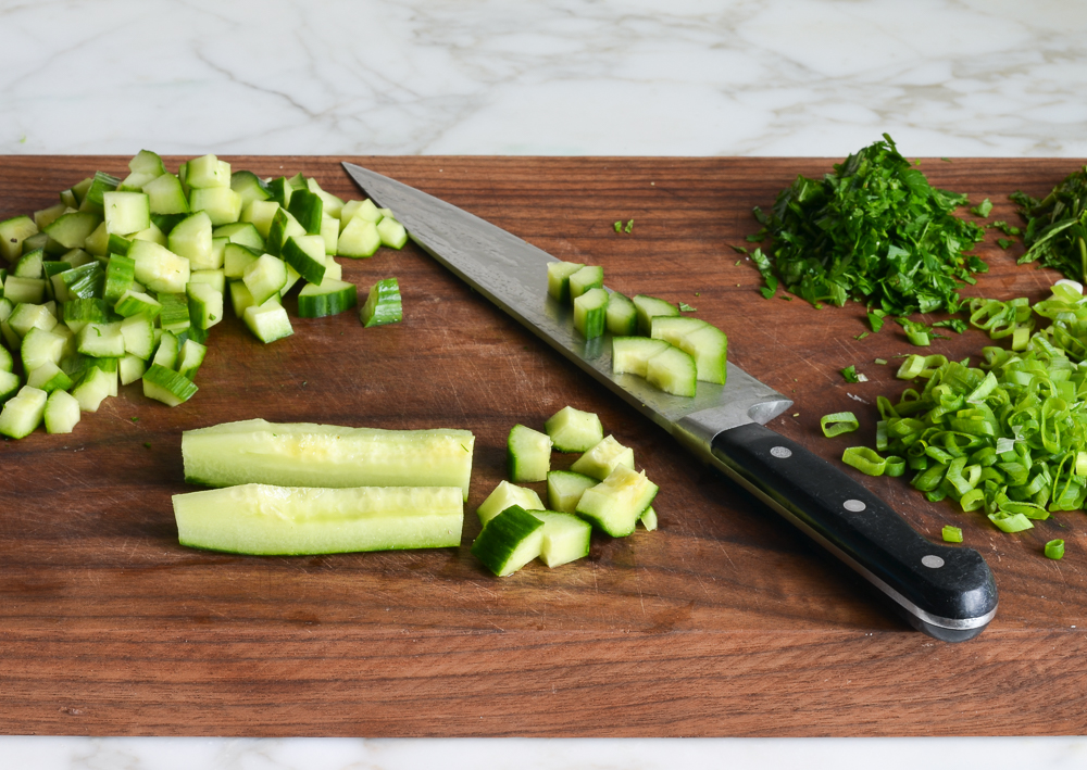 dicing cucumbers on cutting board