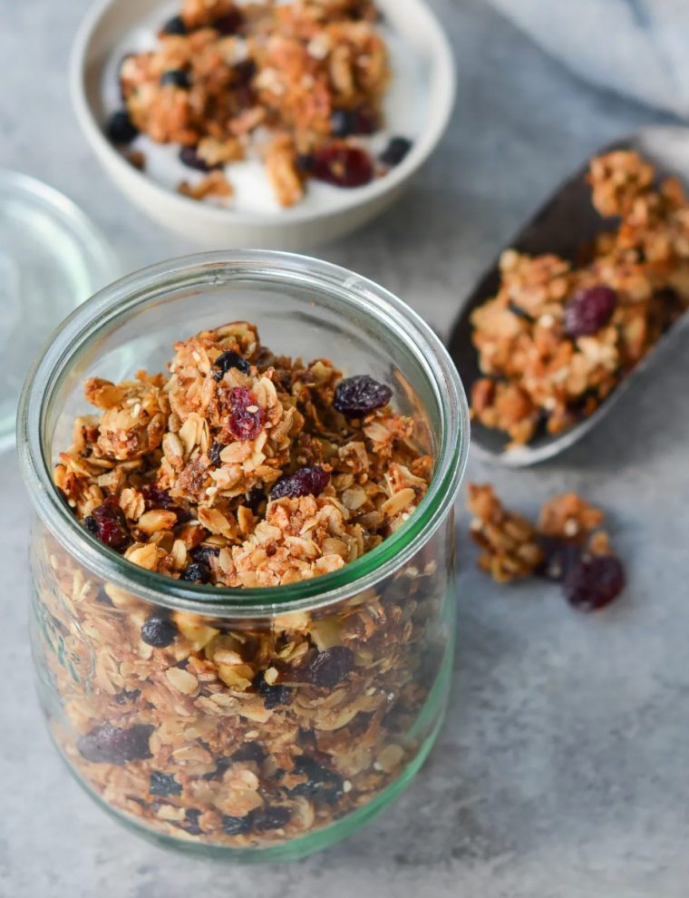 Granola in and around a glass jar.