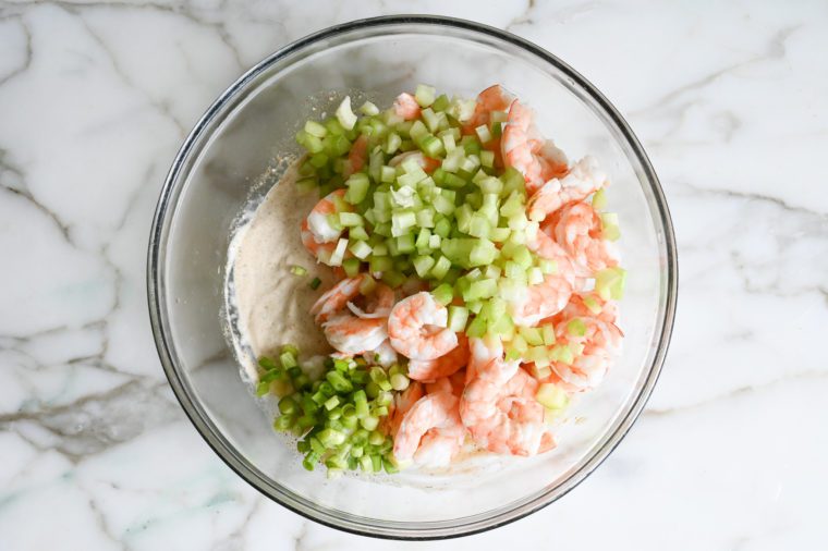 adding the cooked shrimp, celery and light scallions