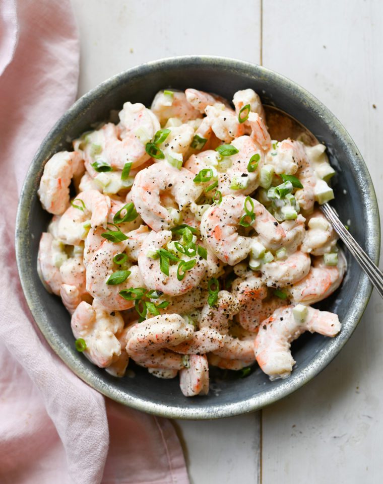 Spoon in a bowl of shrimp salad.