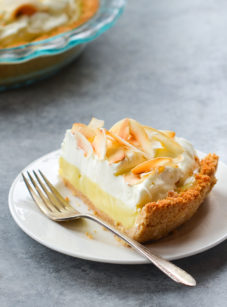 Fork on a plate with a slice of coconut cream pie.