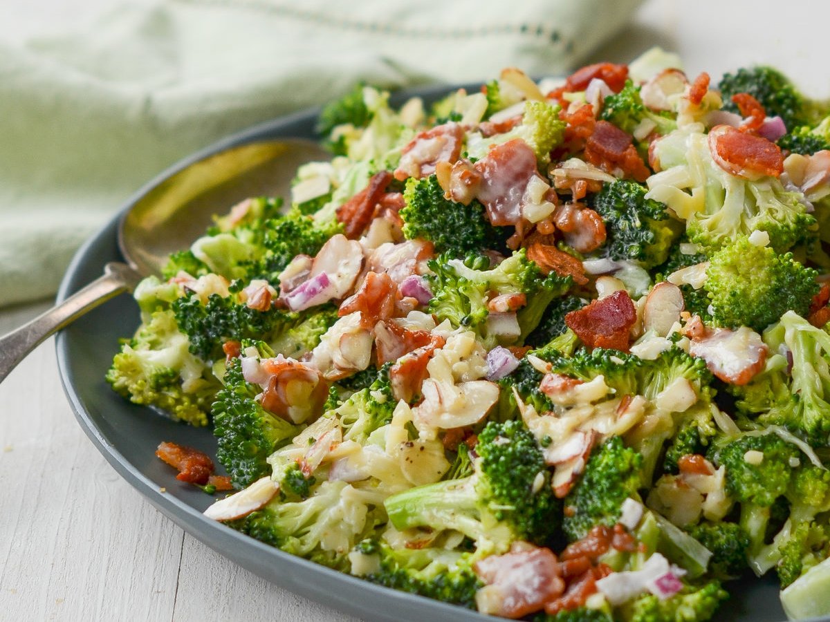 broccoli salad on plate with serving spoon and green linen napkin