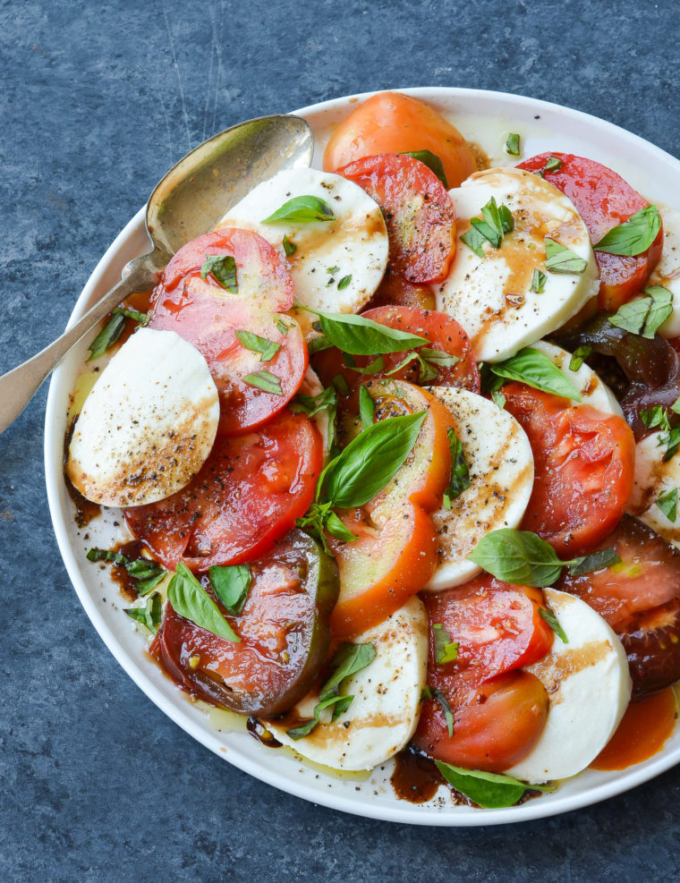 Spoon on a plate with caprese salad.