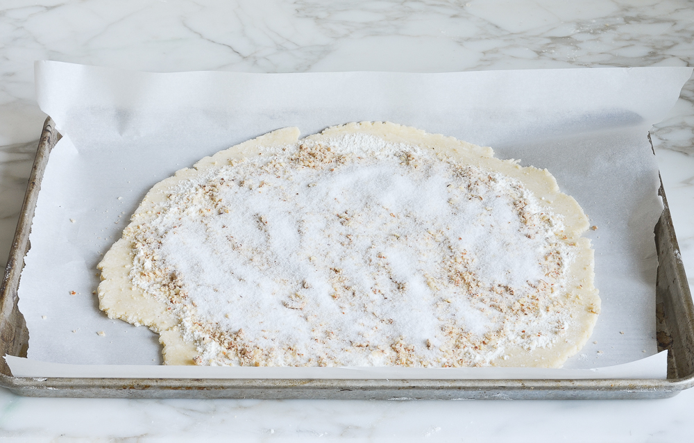 flour, almonds, and sugar sprinkled over dough