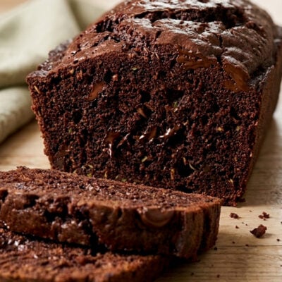 Sliced loaf of chocolate zucchini bread on cutting board.