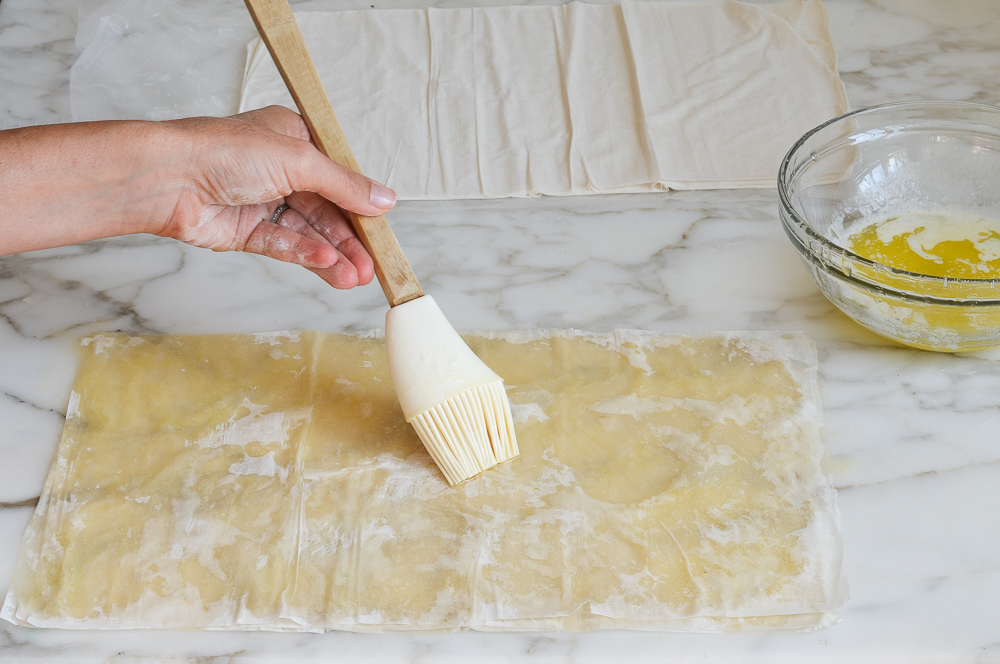 buttering stacked sheets of phyllo