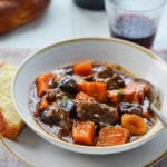 Spoon in a bowl of beef tzimmes.