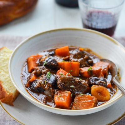 Spoon in a bowl of beef tzimmes.