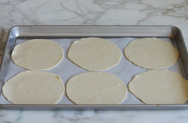 uncooked tortillas on baking sheet.