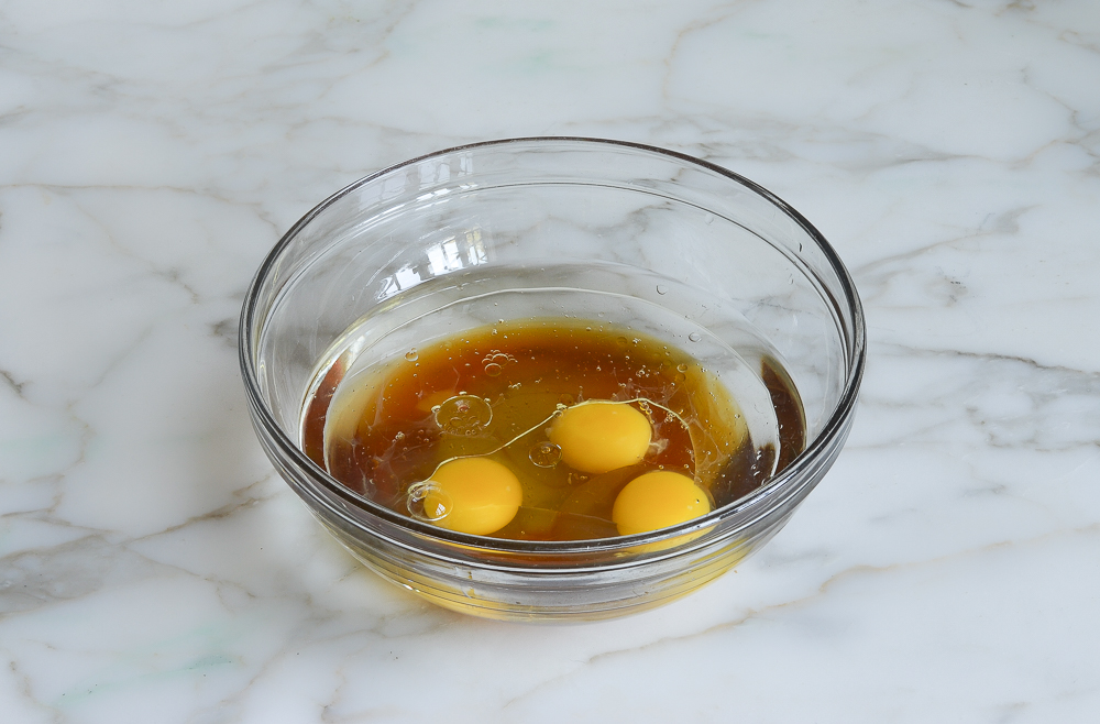 Eggs, water, oil, and honey in a mixing bowl.