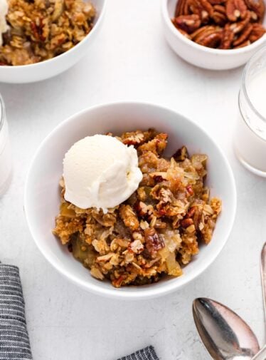 bowl of apple crisp with vanilla ice cream