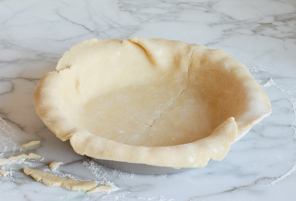 pie crust dough laying in pie dish