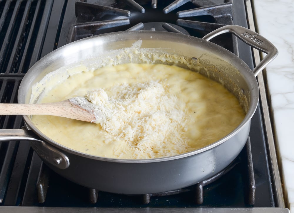 adding cheese to cream sauce