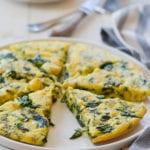 Sliced spinach frittata on a plate.