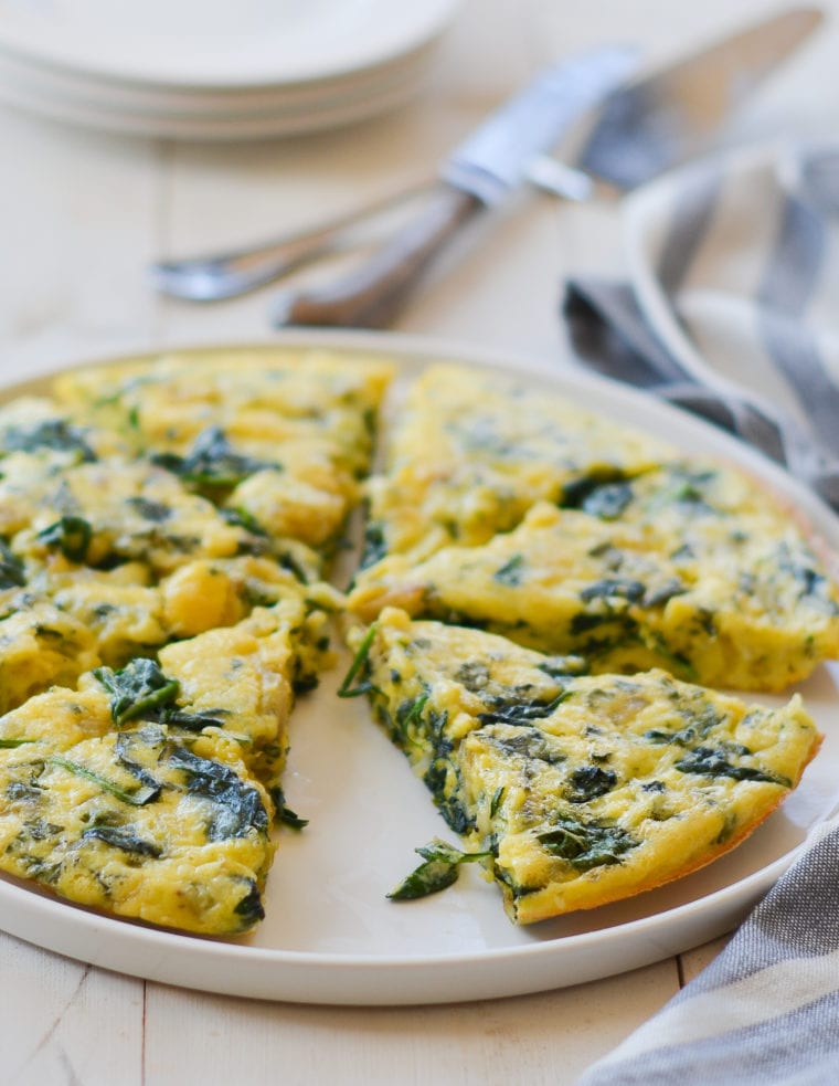 Sliced spinach frittata on a plate.