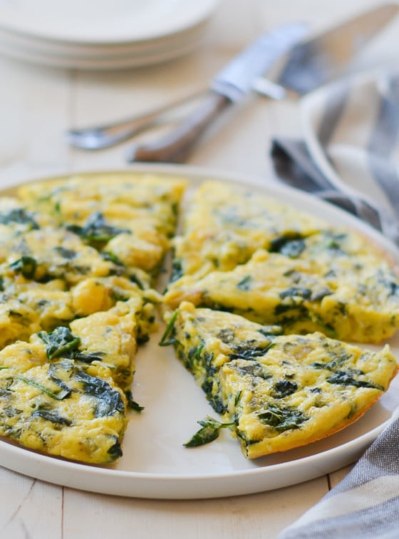 Sliced spinach frittata on a plate.