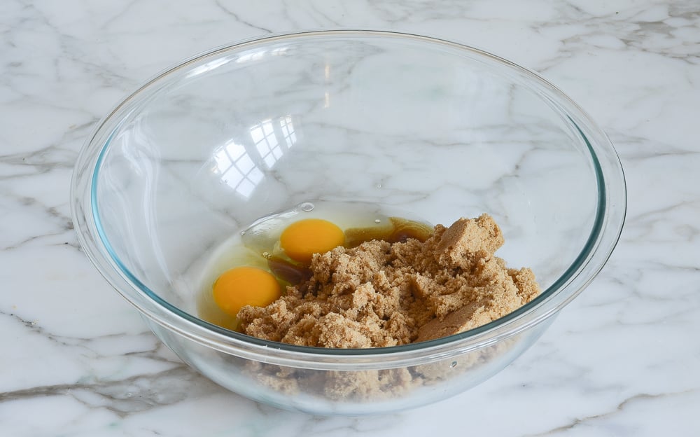Brown sugar, eggs, and vanilla in a bowl.