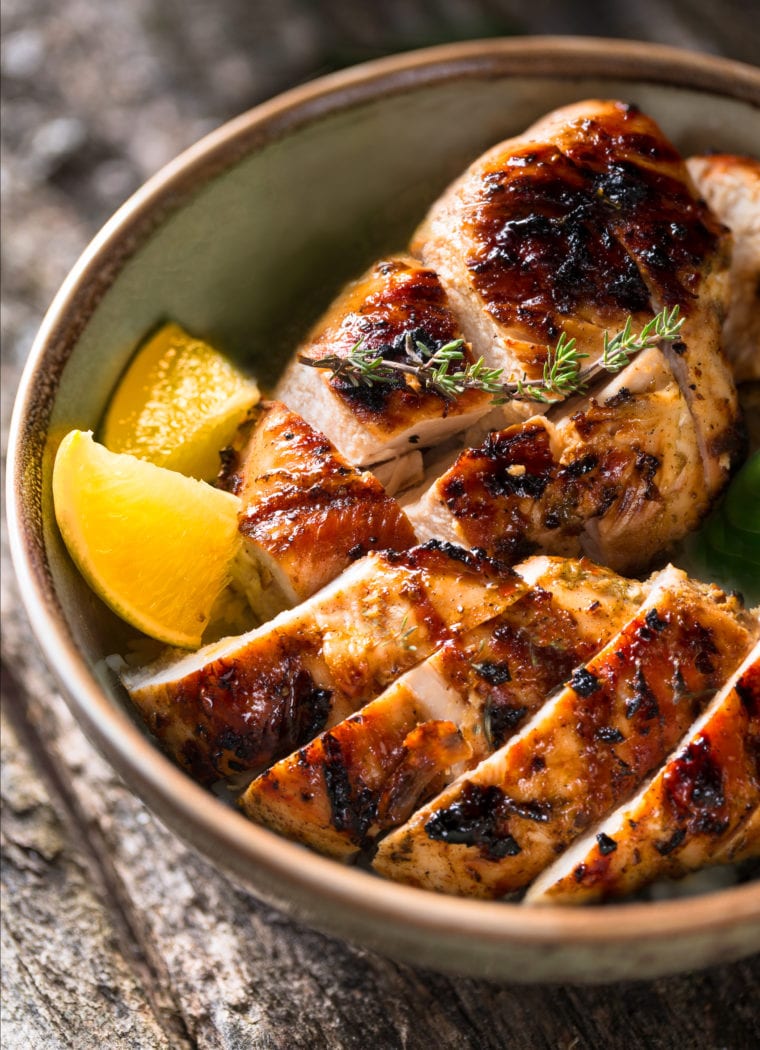 Slices of grilled chicken in a bowl.