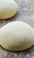 Ball of pizza dough on a floured surface.