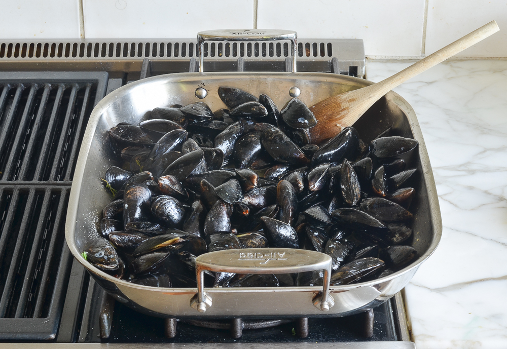 adding mussels to the roasting pan