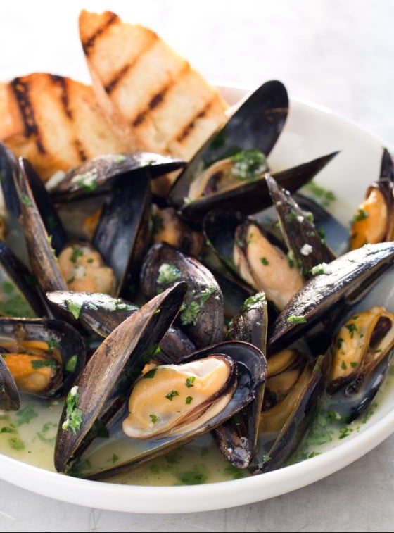 Bowl of oven-steamed mussels with garlic and white wine.