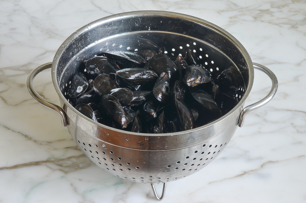 Mussels in a large colander.