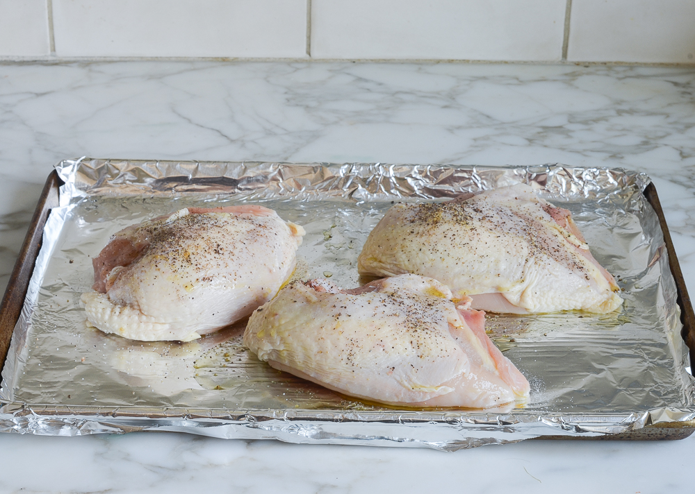 seasoned chicken breasts on baking sheet