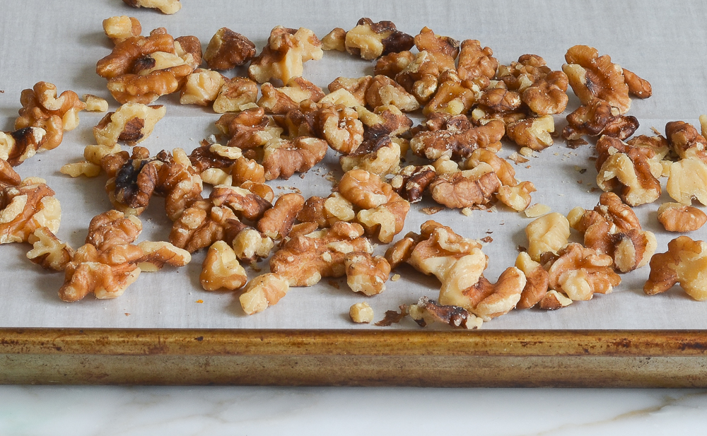 Walnuts on a lined baking sheet.