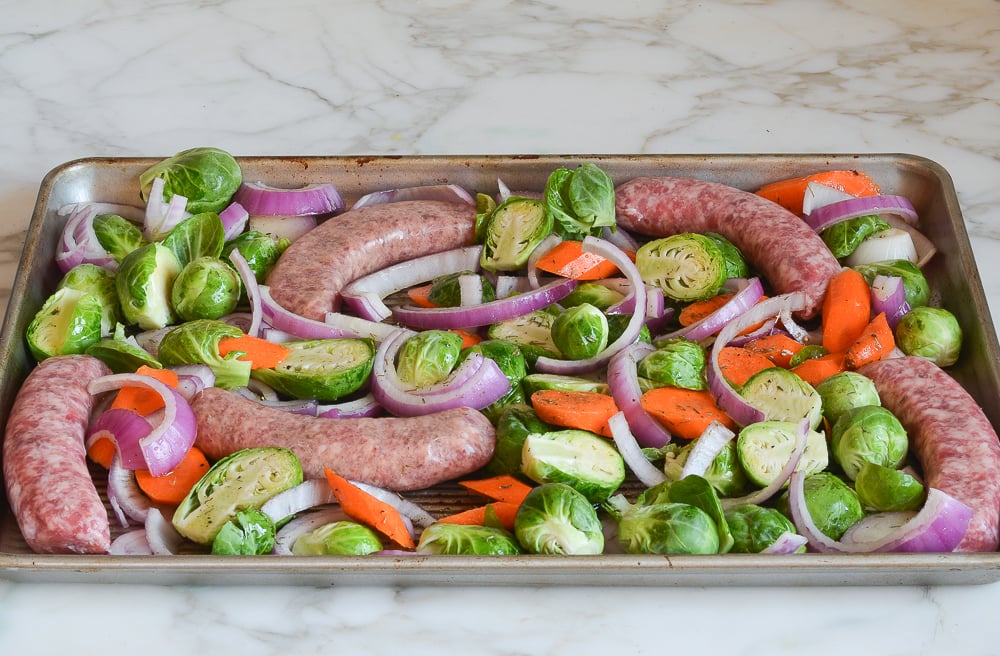 sausage and vegetables arranged on sheet pan