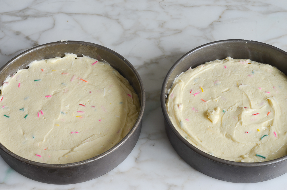 sprinkle cake batter divided into mixing bowls 