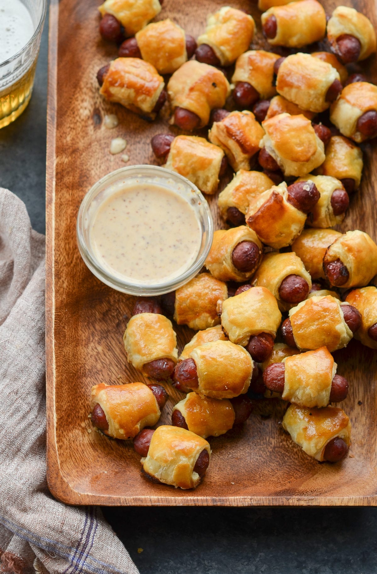 Wooden tray of pigs in a blanket.