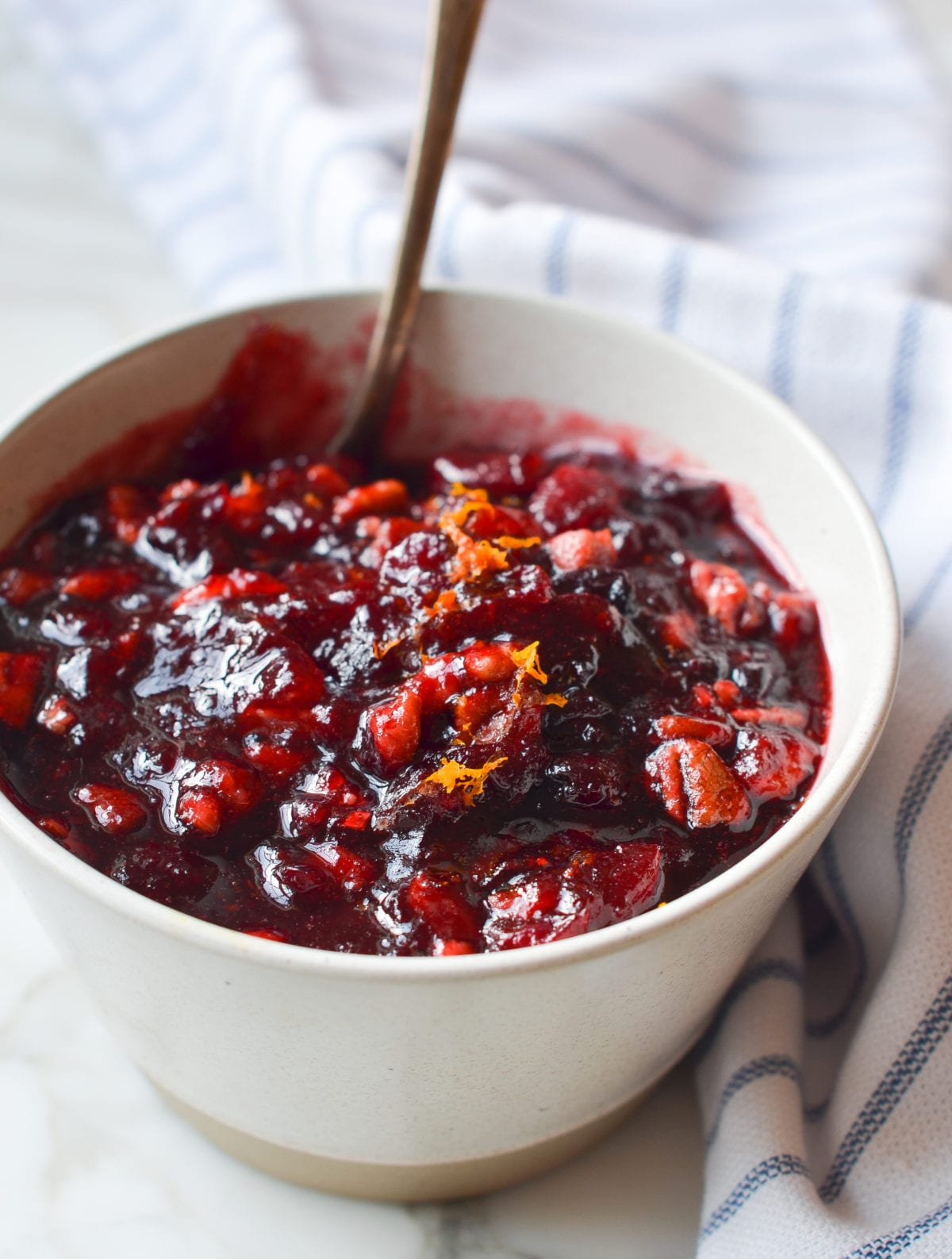Spoon in a bowl of cranberry pecan relish.