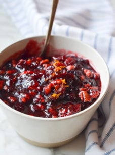 Spoon in a bowl of cranberry pecan relish.